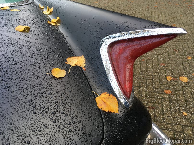 Autumn leaves on rear fender trunk of a black 1960 Chrysler NewYorker